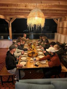 un gruppo di persone sedute a un tavolo che mangiano cibo di KAZA Wave Surf camp a Imsouane