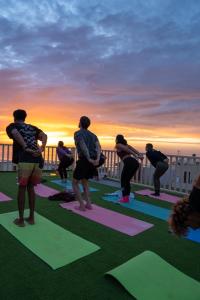 a group of people doing yoga on a balcony at KAZA Wave Surf camp in Imsouane