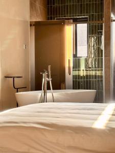 a bathroom with a tub and a sink and a bath tub at Spring Stay Inn 春眠 不覺曉 in Tainan +94 photos