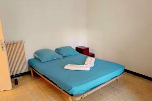 a bedroom with a bed with blue sheets and blue pillows at Spacious house in Perpignan quiet and friendly in Perpignan