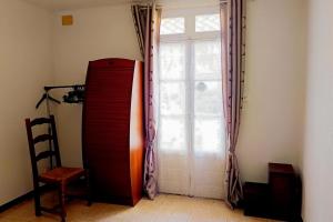 a room with a large window and a red refrigerator at Spacious house in Perpignan quiet and friendly in Perpignan