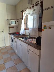 a kitchen with a sink and a refrigerator at Departamentos MDA MIC in Mar de Ajó