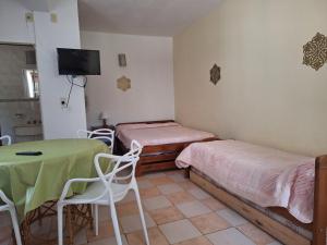 a room with two beds and a table and chairs at Departamentos MDA MIC in Mar de Ajó +19 photos