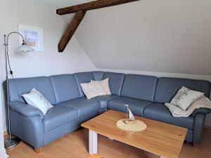 un canapé bleu dans un salon avec une table dans l'établissement Ferienwohnung Fortuna II, à Thiessow