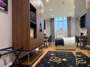 una camera con una camera da letto, un letto e una TV di Empress Boutique Hotel Suites a Mexborough