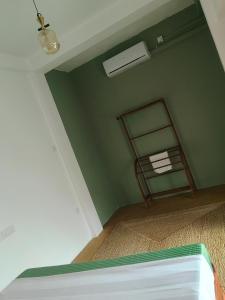 een kamer met een groene muur met een bed erin bij sisi place in Dikwella