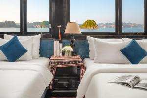 two beds in a room with two windows at Beka Travel Cruise in Cat Ba +31 photos