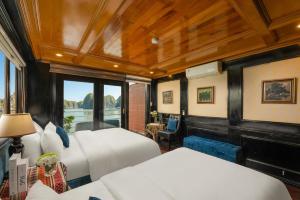 a bedroom with two beds and a large window at Beka Travel Cruise in Cat Ba