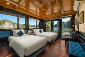 two beds in a room with large windows at Beka Travel Cruise in Cat Ba