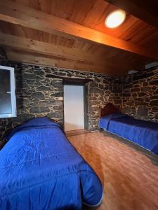 a bedroom with a bed and a stone wall at Casa Duque in Santana with AC and heating in Santana