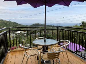 einen Tisch und Stühle auf einem Balkon mit Sonnenschirm in der Unterkunft Jilufugan B&B in Taimali