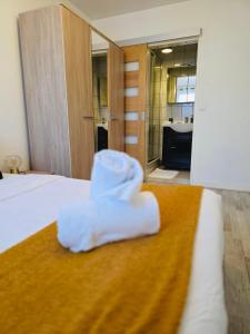 een witte handdoek bovenop een bed bij Le Cocon Bright Large TV Free parking in Fleury-les-Aubrais