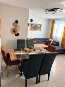 a dining room with a table and a couch at Le Cocon Bright Large TV Free parking in Fleury-les-Aubrais