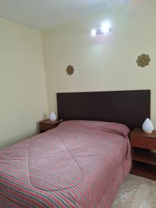 a bedroom with a bed with a red and blue striped blanket at Departamentos MDA MIC in Mar de Ajó