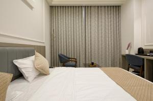 a hotel room with a bed and a table and chairs at The Grand Platinum Hotel in Ahmedabad