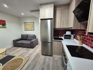 a kitchen with a stainless steel refrigerator and a chair at Escola in Ourense