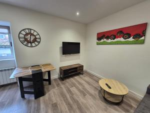 a living room with a table and a flat screen tv at Escola in Ourense