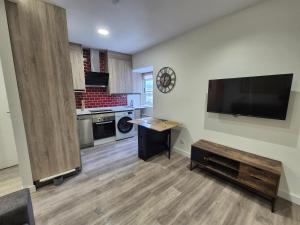 a kitchen with a large flat screen tv on the wall at Escola in Ourense