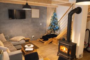 a living room with a fireplace and a christmas tree at Chata pod Kriváňom in Východná