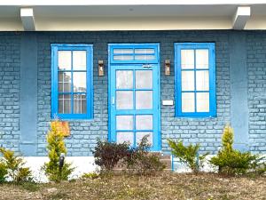 a blue door and windows on a house at Private Farm Villa With Plunge Pool, Bir Billing - Rishi Casa Blu in Bīr