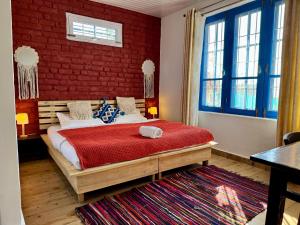 a bedroom with a large bed with a red brick wall at Private Farm Villa With Plunge Pool, Bir Billing - Rishi Casa Blu in Bīr