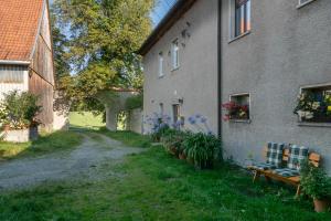un sentiero accanto a un edificio con una panchina e dei fiori di Ferienwohnung Reichel a Remptendorf