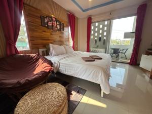 een slaapkamer met een bed, een bank en een raam bij Jingle Bells Resort in Ko Larn