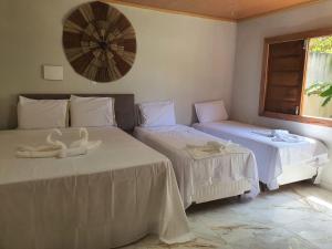 two beds in a room with swans on them at Bangalô em uma área próxima a praia e centro in Porto Seguro