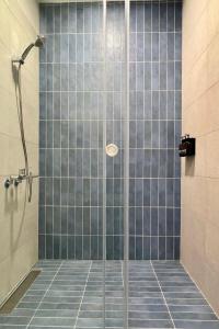 una doccia con piastrelle di vetro blu in un bagno di Forgotten Boundless Offland a Wujie