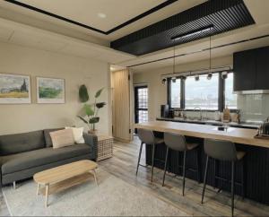 a kitchen and living room with a couch and a table at OFFLand 遺忘無際 宜蘭 4-6人 小包棟民宿 in Wujie