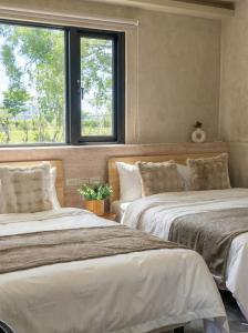 two beds in a room with a window at Forgotten Boundless Offland in Wujie