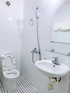 une salle de bains blanche avec toilettes et lavabo dans l'établissement Sao Mai Hotel Hạ Long, à Hạ Long