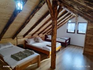 a room with two beds in a wooden cabin at River Haus in Călineşti