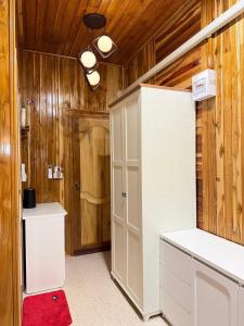 een kamer met een witte kast en een rood tapijt bij ห้างหุ้นส่วนจำกัด บ้านเถ้าแก่ in Ban Muang Baeng