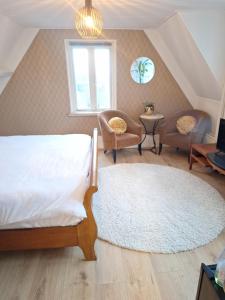 a bedroom with a bed and chairs and a window at 't Wapen van Middelie in Middelie