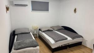 a bedroom with two beds and a flat screen tv at Hetes7 Villa Negra in Hetes
