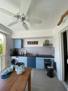 a kitchen with a table and a ceiling fan at Appart Flamboyant 1006 in Saint Martin