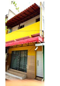 un edificio giallo con una tenda rossa sopra di Apê da Lili a Ilha de Boipeba