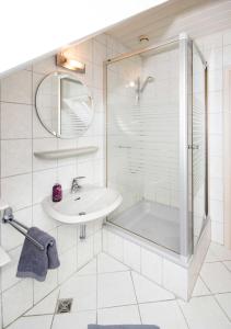 een witte badkamer met een wastafel en een douche bij Studiowohnung in Hohnstorf