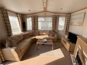 a living room with a couch and a table at Seaside Sanctuary in Hemsby