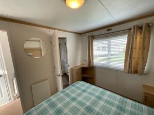 a small room with a bed and a window at Seaside Sanctuary in Hemsby