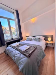 a bedroom with two beds and a large window at Schuman Square Residence in Brussels