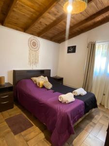 a bedroom with a purple bed with towels on it at Evergreen in Mar del Plata
