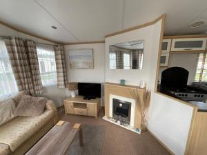 a living room with a couch and a fireplace at Seaside Sanctuary in Hemsby