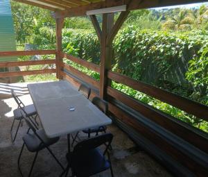 a picnic table and chairs on a screened in porch at Bungalow citron in Petit-Bourg