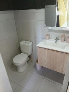 een witte badkamer met een toilet en een wastafel bij Bungalow citron in Petit-Bourg
