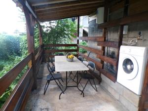 a patio with a table and a washing machine at Bungalow citron in Petit-Bourg