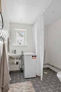 un bagno bianco con lavandino e WC di Älvbacken a Västerlanda Altre 39 foto