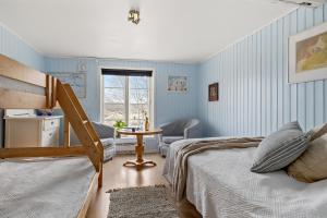 una camera da letto con pareti blu e un letto e una sedia di Älvbacken a Västerlanda