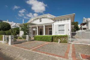 een wit huis met een hek ervoor bij Story Haus in Stellenbosch
